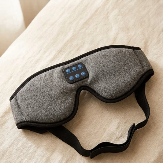 The Sound Sleep Mask grey variant with Bluetooth controls on neutral surface — Kosient